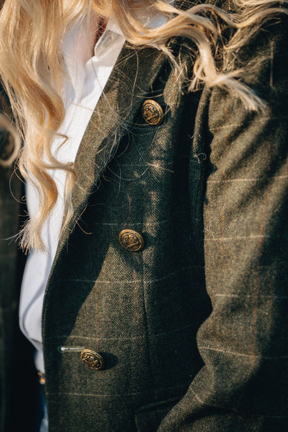 Close-up of a person wearing a dark green textured coat with gold buttons.
